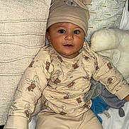 Zayn participe au concours pour gagner de l'argent avec cette photo : baby, infant, beanie, hat, pajamas, pillow, blanket, bedding, plush, stuffed_animal, portrait, cute, smiling, eyes, eyelashes, cozy, hands, sitting, home, nursery