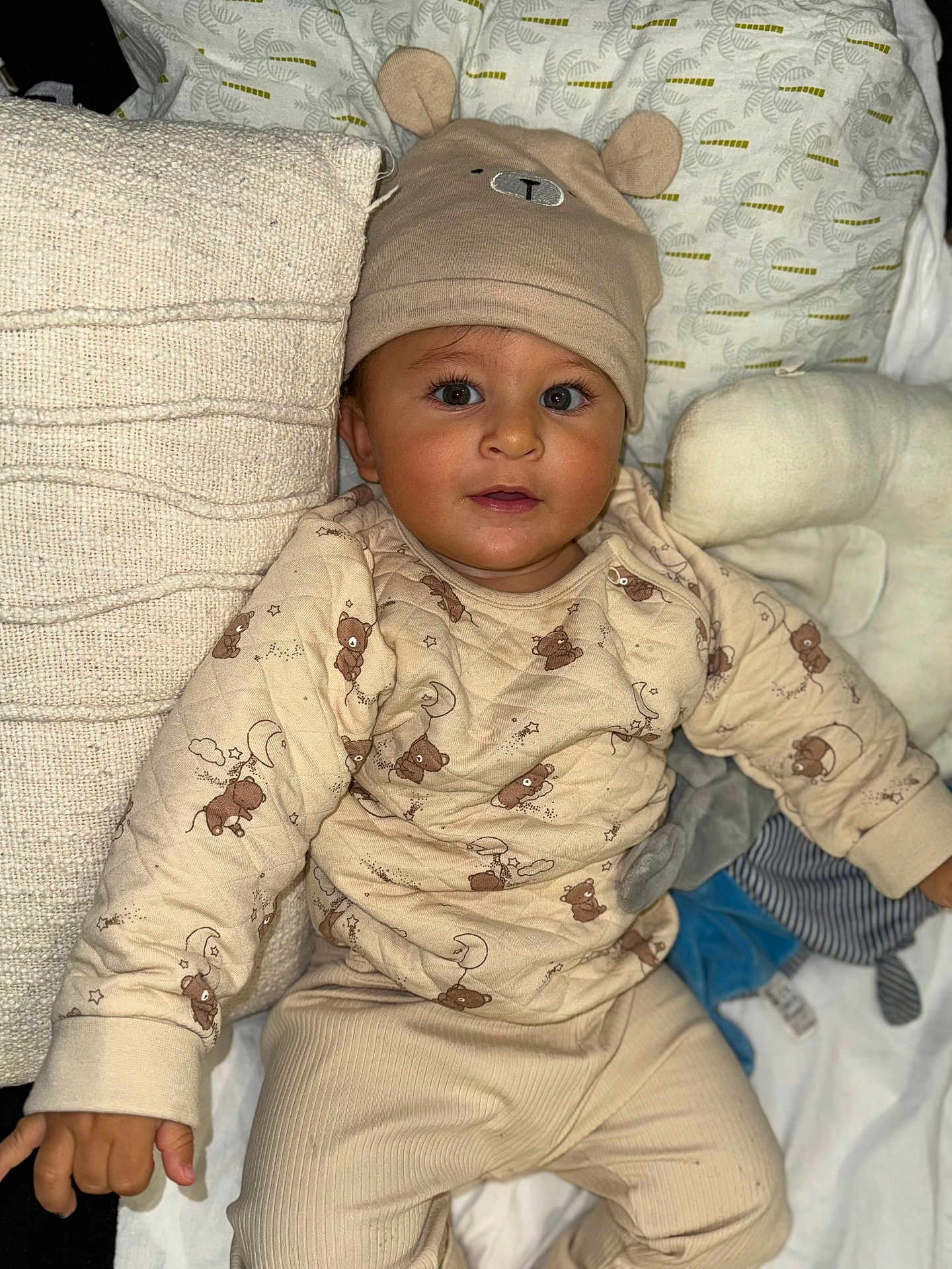 Zayn participe au concours pour gagner de l'argent avec cette photo : baby, infant, beanie, hat, pajamas, pillow, blanket, bedding, plush, stuffed_animal, portrait, cute, smiling, eyes, eyelashes, cozy, hands, sitting, home, nursery