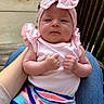 baby, backyard, chair, child, date_stamp, face, flowers, hands, headband, held_baby, infant, outdoor, pink_bow, portrait, rainbow_pants, serious_expression, sitting, socks, striped_clothing, wooden_deck