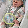 baby, infant, child, smiling, sitting, rocker, baby_seat, floral_clothing, headband, bow, plush_toy, toy, harness, portrait, indoor, patterned_blanket, cozy, happy, face, date_stamp