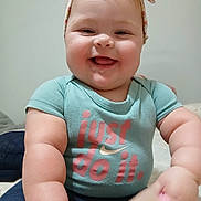 Allison joined the competition — help win amazing prizes! baby, blue_shirt, child, closeup, clothing, cute, face, hand, happy, headband, indoor, infant, laughing, person, portrait, sitting, skin, smiling, text_on_clothing, toy