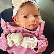 Aira joined the competition — help win amazing prizes! baby, infant, child, headband, bow, mittens, pink_clothing, closeup, portrait, cute, newborn, face, expression, soft_lighting, indoor, person, young_child, apparel, baby_clothes, adorable