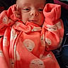 baby, infant, onesie, orange_clothing, sleepy_moon_pattern, hands_near_face, curious_expression, portrait, closeup, cozy, cute, child, newborn, soft_fabric, indoor, warm, small_hands, head, face, eyes