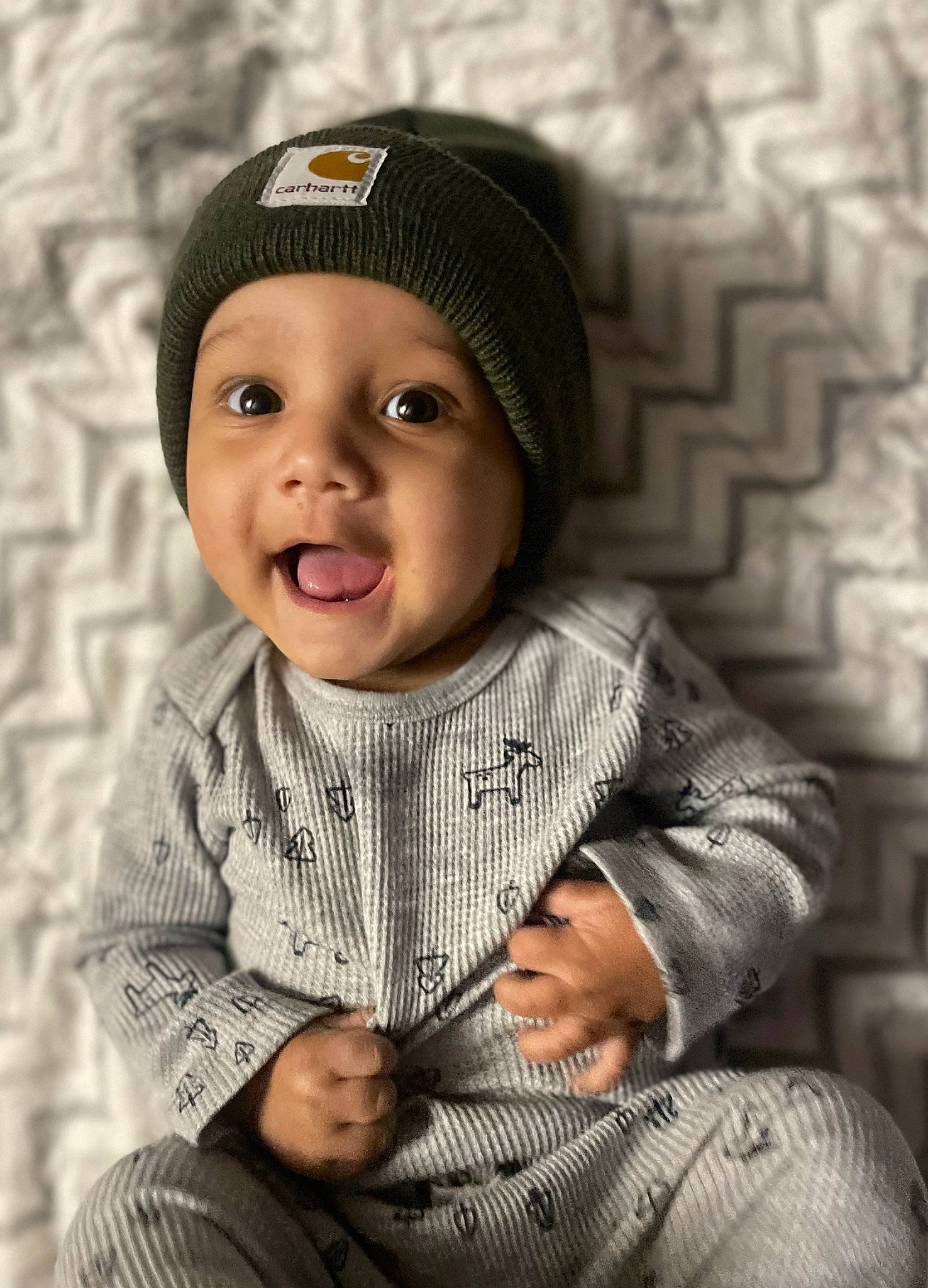 Lennox is registered to the contest to win money with this photo: arm, baby, baby_toddler_clothing, cap, cheek, child, clothing, cool, eye, flash_photography, hand, happy, headwear, outerwear, pattern, people, person, skin, sleeve, standing