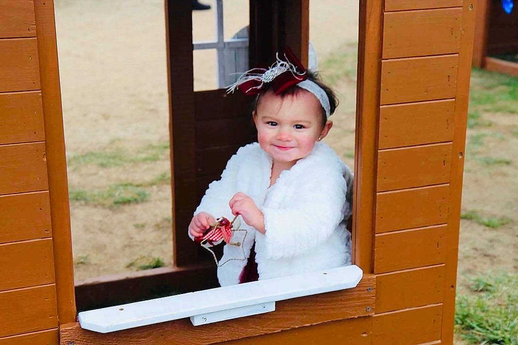 Giuliana is registered to the contest to win money with this photo: baby_toddler_clothing, child, door, eye, fun, grass, happy, joy, leisure, magenta, person, photograph, pink, playhouse, recreation, room, smile, standing, toddler, tree