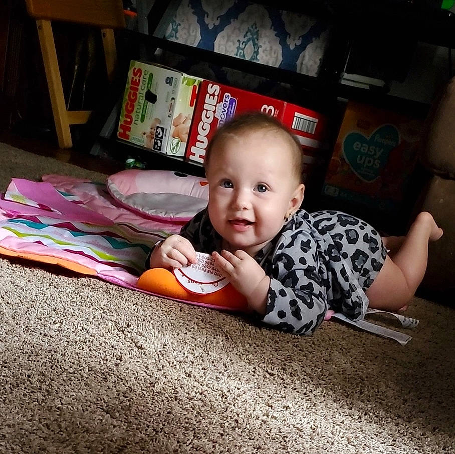 Brooklyn joined the competition — help win amazing prizes! baby, baby_toddler_clothing, carpet, child, comfort, crawling, electronic_device, floor, flooring, fun, happy, hardwood, linens, living_room, person, room, sitting, smile, t_shirt, toddler
