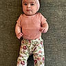 baby, infant, headband, bow, pink_clothing, floral_pants, lying_down, curious_expression, cute, child, portrait, indoors, texture, fabric, small_hands, barefoot, casual_outfit, baby_fashion, chubby_cheeks, looking_at_camera