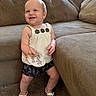 toddler, child, baby, smiling, standing, living_room, couch, carpet, white_top, shorts, sandals, wooden_sign, nine_months, happy, indoor, person, portrait, cute, clothing, home