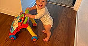 Zaria joined the competition — help win amazing prizes! baby, walker, toy, wooden_floor, carpet, bed, superhero_bed, smile, standing, indoor, child, room, happy, footwear, pajamas, furniture, wall, doorway, playroom, infant