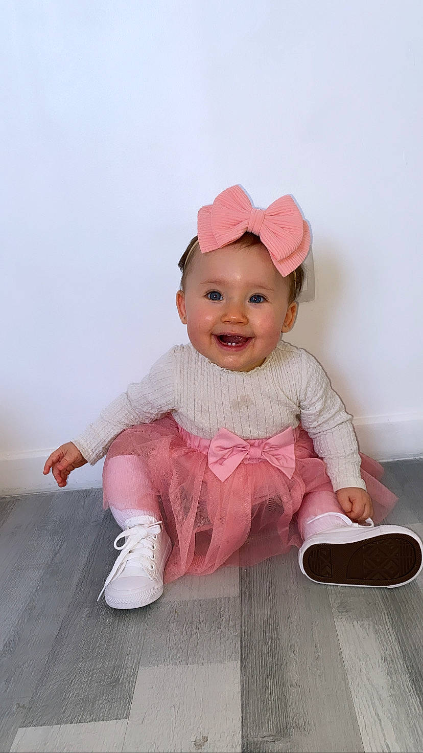 Mya a rejoint le concours — aidez-le/la à gagner de superbes lots ! baby, baby_toddler_clothing, cap, child, fashion_accessory, flash_photography, flooring, fun, happy, hat, headgear, joy, magenta, pattern, person, pink, portrait_photography, sitting, sleeve, smile