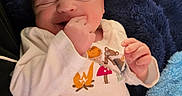 August is registered to the contest to win money with this photo: newborn, baby, infant, sleeping, yawning, smiling, face, portrait, blanket, blue_blanket, swaddled, onesie, clothing, hand, finger, indoor, cozy, close_up, seated, soft_lighting