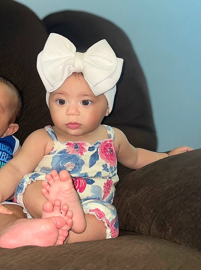 Evie joined the competition — help win amazing prizes! baby, baby_toddler_clothing, beanie, cap, cheek, child, chin, comfort, fashion_accessory, flash_photography, foot, fun, happy, headband, headgear, headwear, pattern, person, sitting, skin