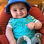 baby, child, smiling, blue_hat, turquoise_outfit, plush_toy, koala, cushioned_chair, indoors, cute, portrait, happy, hand, face, headwear, toy, infant, childhood, comfort, playful