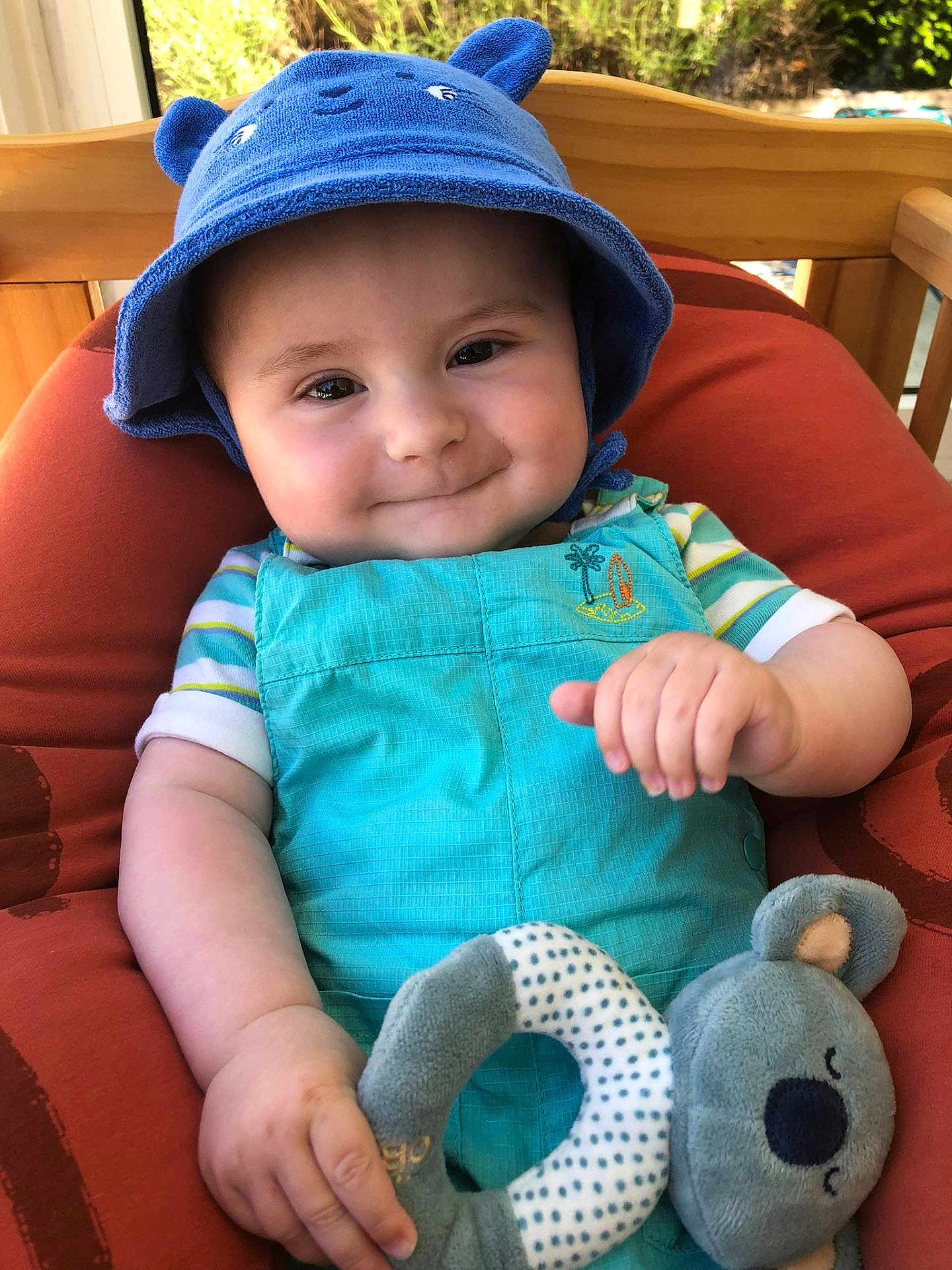 Louis-Gabriel a rejoint le concours — aidez-le/la à gagner de superbes lots ! baby, child, smiling, blue_hat, turquoise_outfit, plush_toy, koala, cushioned_chair, indoors, cute, portrait, happy, hand, face, headwear, toy, infant, childhood, comfort, playful