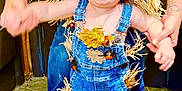 Ripp is registered to the contest to win money with this photo: autumn_leaves, child, cute, denim_overalls, floor, footwear, hands_held, happy, hat, holding_hands, indoor, jeans, person, playful, scarecrow_costume, smiling, straw, support, toddler, tongue_out
