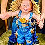 toddler, child, scarecrow_costume, denim_overalls, straw, autumn_leaves, playful, tongue_out, hands_held, floor, indoor, person, cute, smiling, hat, footwear, jeans, holding_hands, happy, support