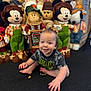 toddler, child, baby, crawling, carpet, plush_toys, mickey_mouse, scarecrow, doll, indoor, smiling, clothing, person, toy, cute, playful, background, colorful, happy, floor