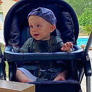 Lyam participe au concours pour gagner de l'argent avec cette photo : baby, boy, cap, casual_clothing, child, curious, daytime, expression, greenery, infant, nature, outdoor, pool, portrait, relaxing, seat, stroller, summer, sunlight, young_child