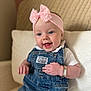 baby, blue_eyes, bracelet, child, clothing, couch, cute, denim_overalls, hand, happy, headband, indoor, infant, pink_bow, portrait, sitting, skin, smile, white_shirt, young