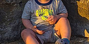 Nixon joined the competition — help win amazing prizes! toddler, child, smiling, curly_hair, outdoor, rock, stone_steps, casual_clothing, shorts, tshirt, footwear, sunlight, happy, sitting, portrait, cute, young, playful, nature, daylight