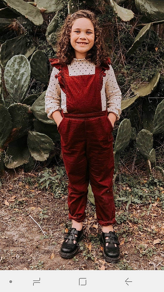 Aalieghia is registered to the contest to win money with this photo: child, child_model, fawn, joy, maroon, outerwear, overall, person, red, smile, toddler, trousers