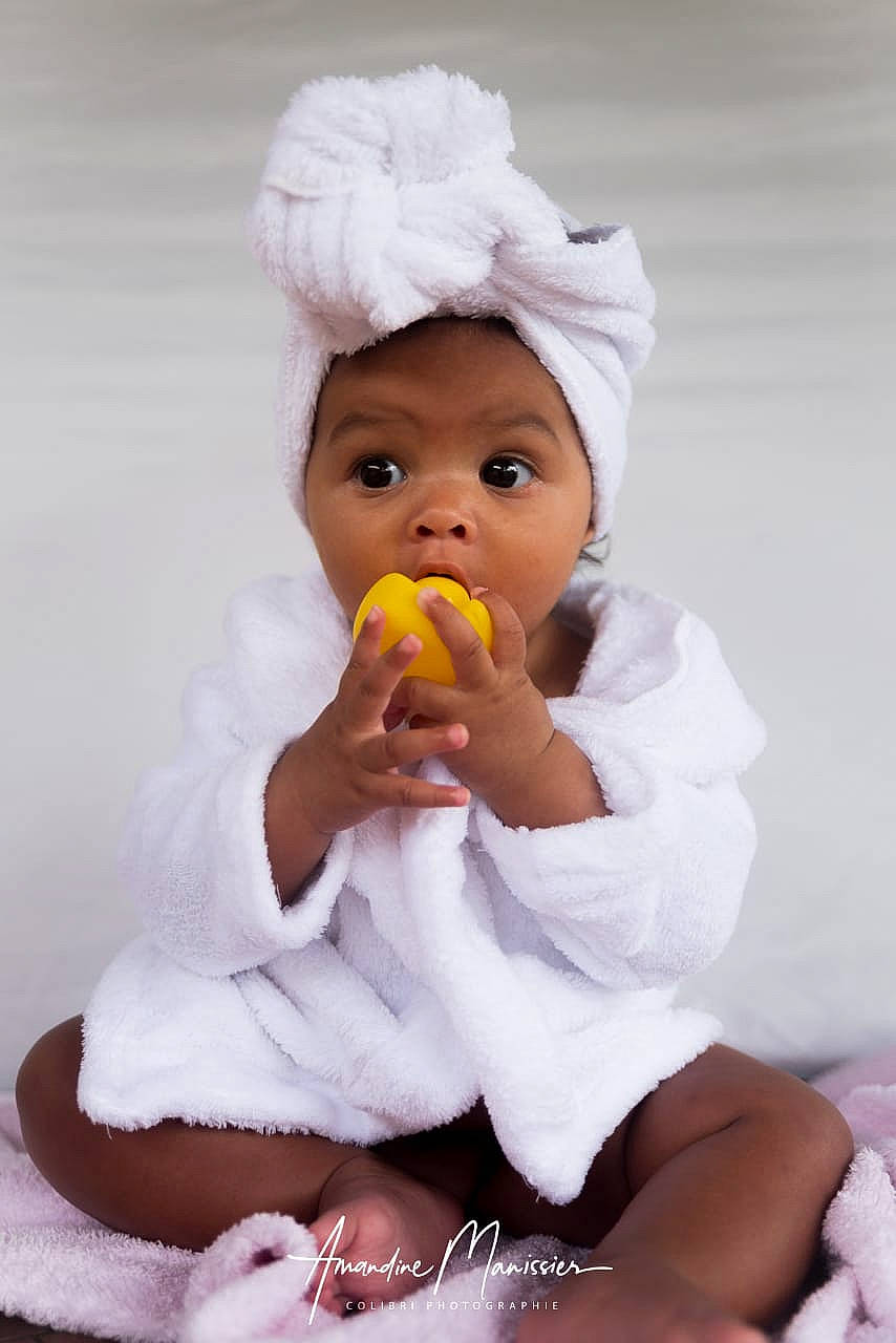 Kylissane a rejoint le concours — aidez-le/la à gagner de superbes lots ! baby, baby_products, baby_sleeping, baby_toddler_clothing, beanie, cap, child, comfort, finger, fun, gesture, happy, human_leg, mouth, nail, person, play, sitting, surprise, sweetness