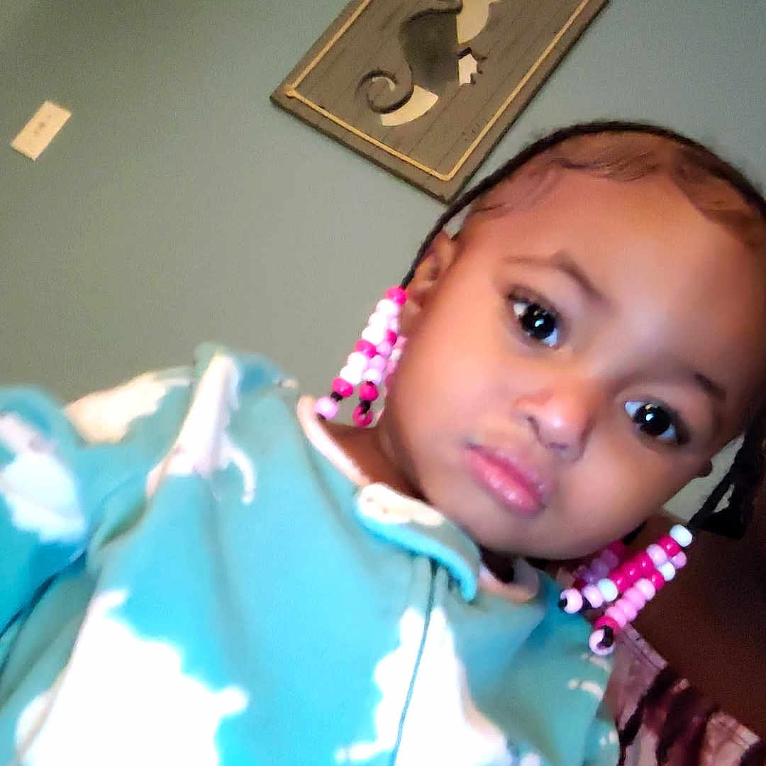 Nylynn is registered to the contest to win money with this photo: toddler, child, indoor, onesie, blue_clothing, braided_hair, beads, curious, face, portrait, seahorse_art, wall_decoration, light_switch, person, young_child, cute, home, cozy, clothing_pattern, baby