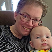 Elizabeth joined the competition — help win amazing prizes! adult, baby, glasses, striped_clothing, floral_clothing, indoor, window, smile, face, person, child, portrait, happy, seated, closeup, head, family, love, cozy, home