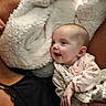 Elizabeth is registered to the contest to win money with this photo: baby, infant, smiling, blanket, soft_texture, adult, black_clothing, skin, head, face, happy, comfort, cuddle, closeup, portrait, indoor, cozy, person, expression, warmth