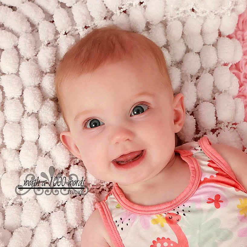 Elizabeth joined the competition — help win amazing prizes! baby, infant, child, smiling, portrait, close_up, lying_down, blanket, pink, white, fluffy, baby_clothing, floral_pattern, indoors, photography, face, eyes, red_hair, happy, watermark