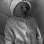 baby, sleeping, hat, pom_pom, blanket, onesie, heart_pattern, infant, cozy, soft, bed, rest, cute, warm, face, clothing, newborn, portrait, peaceful, monochrome