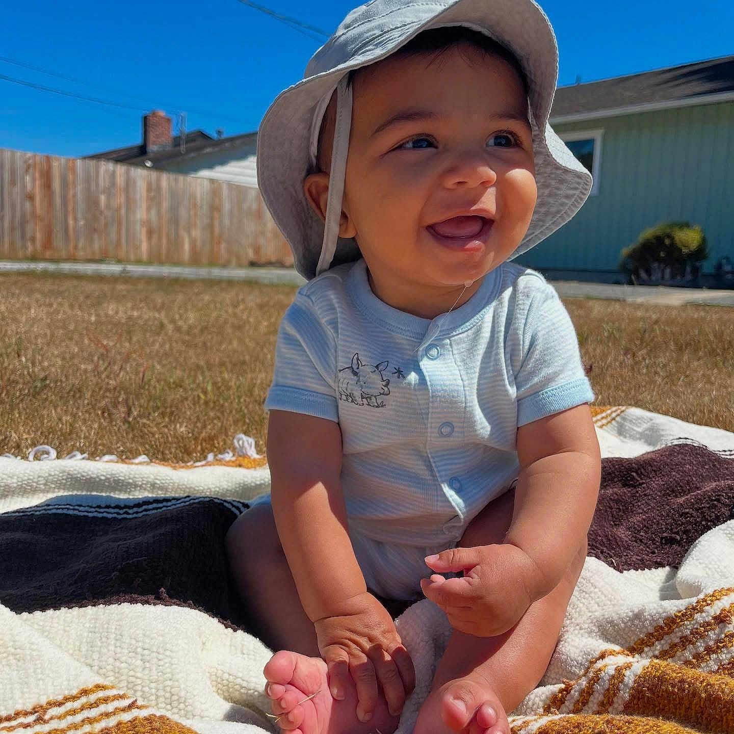 Miles is registered to the contest to win money with this photo: baby, blanket, blue_sky, child, cute, drool, feet, grass, hands, happy, home, infant, onesie, outdoor, portrait, sitting, smiling, sunhat, sunny, yard