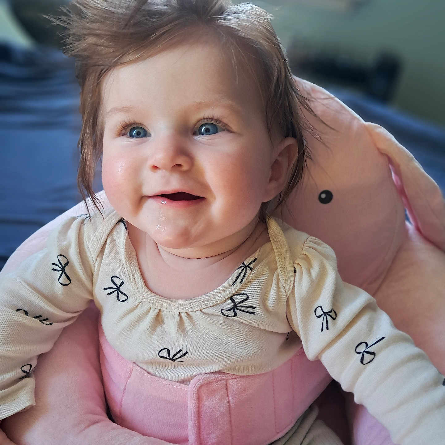 Daisy is registered to the contest to win money with this photo: baby, child, blue_eyes, smiling, hair, pink, plush, seat, indoor, soft_toys, cute, happy, clothing, infant, face, person, toddler, comfort, portrait, window