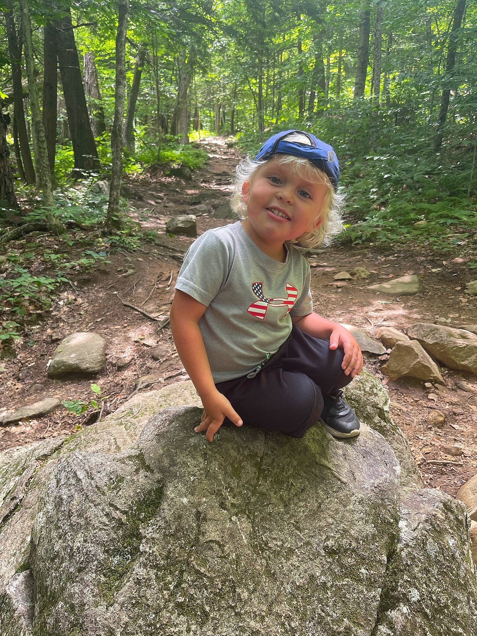 Rowan is registered to the contest to win money with this photo: adaptation, bedrock, child, forest, fun, grass, groundcover, headwear, joy, landscape, leisure, natural_landscape, people_in_nature, person, plant, plant_community, recreation, terrestrial_plant, toddler, tree