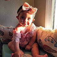 Frannie joined the competition — help win amazing prizes! baby, child, girl, headband, bow, pink_outfit, cushion, bench, window, sunlight, wooden_sign, nine_months, flower_wall_decor, indoor, cute, smiling, sitting, hand, foot, portrait