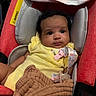 baby, infant, yellow_clothing, pacifier, blanket, red_seat, cushion, child, indoors, cute, face, person, newborn, portrait, comfort, soft, expression, closeup, young, seated
