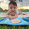 baby, infant, smiling, blanket, outdoor, grass, wooden_plaque, milestone, face, portrait, child, nature, sunset, cute, happy, toddler, young_child, clothing, head, expression