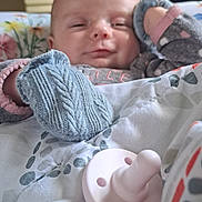 Oaklynn is registered to the contest to win money with this photo: baby, blanket, mittens, pacifier, sleepy, indoor, face, person, child, soft, pattern, cozy, cute, infant, bedroom, comfort, resting, warm, clothing, portrait