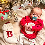 Beckett joined the competition — help win amazing prizes! baby, infant, christmas_tree, christmas_lights, christmas_ornament, stocking, blanket, pajamas, pacifier, holiday, festive, snow_flocked_tree, red_clothing, cozy, indoors, cute, newborn, decorations, soft_texture, celebration