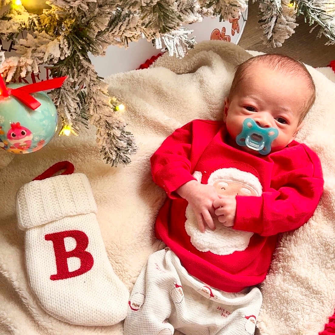 Beckett joined the competition — help win amazing prizes! baby, blanket, celebration, christmas_lights, christmas_ornament, christmas_tree, cozy, cute, decorations, festive, holiday, indoors, infant, newborn, pacifier, pajamas, red_clothing, snow_flocked_tree, soft_texture, stocking