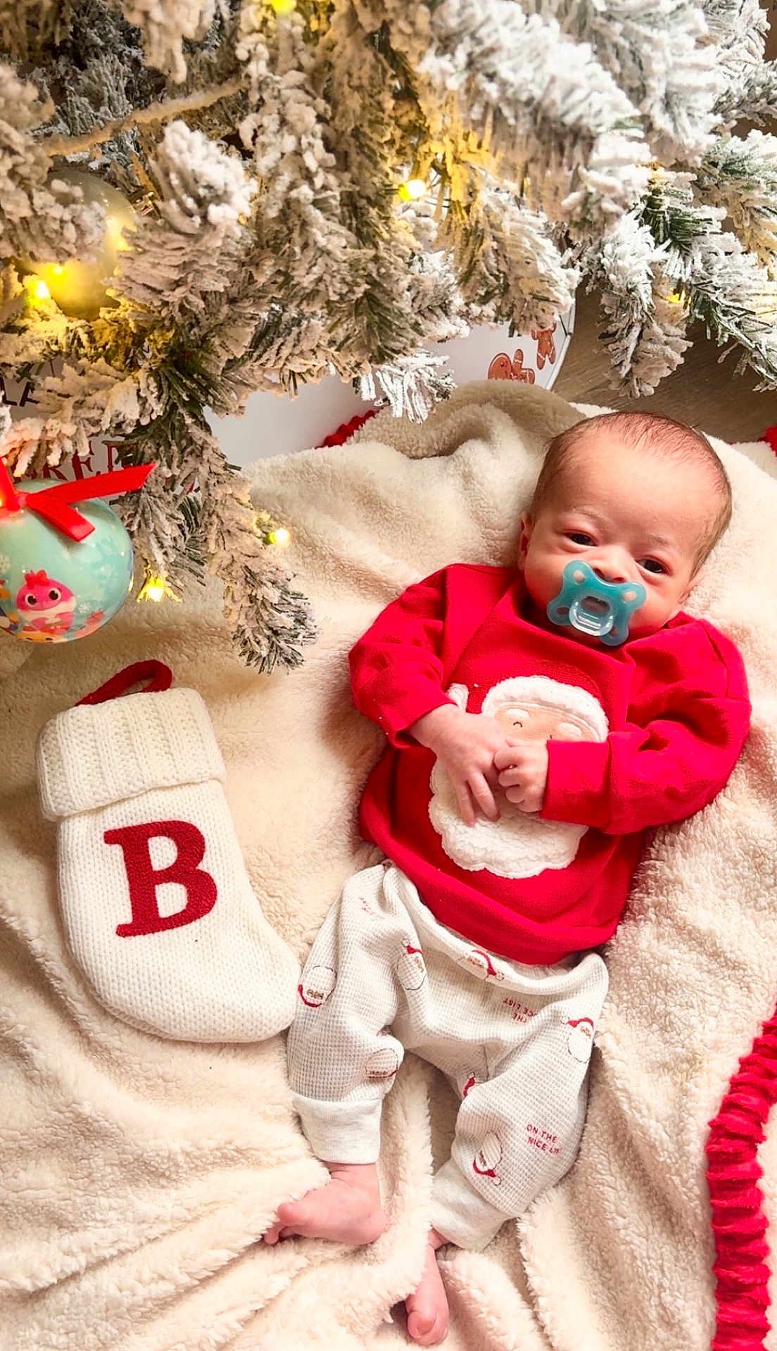 Beckett joined the competition — help win amazing prizes! baby, infant, christmas_tree, christmas_lights, christmas_ornament, stocking, blanket, pajamas, pacifier, holiday, festive, snow_flocked_tree, red_clothing, cozy, indoors, cute, newborn, decorations, soft_texture, celebration