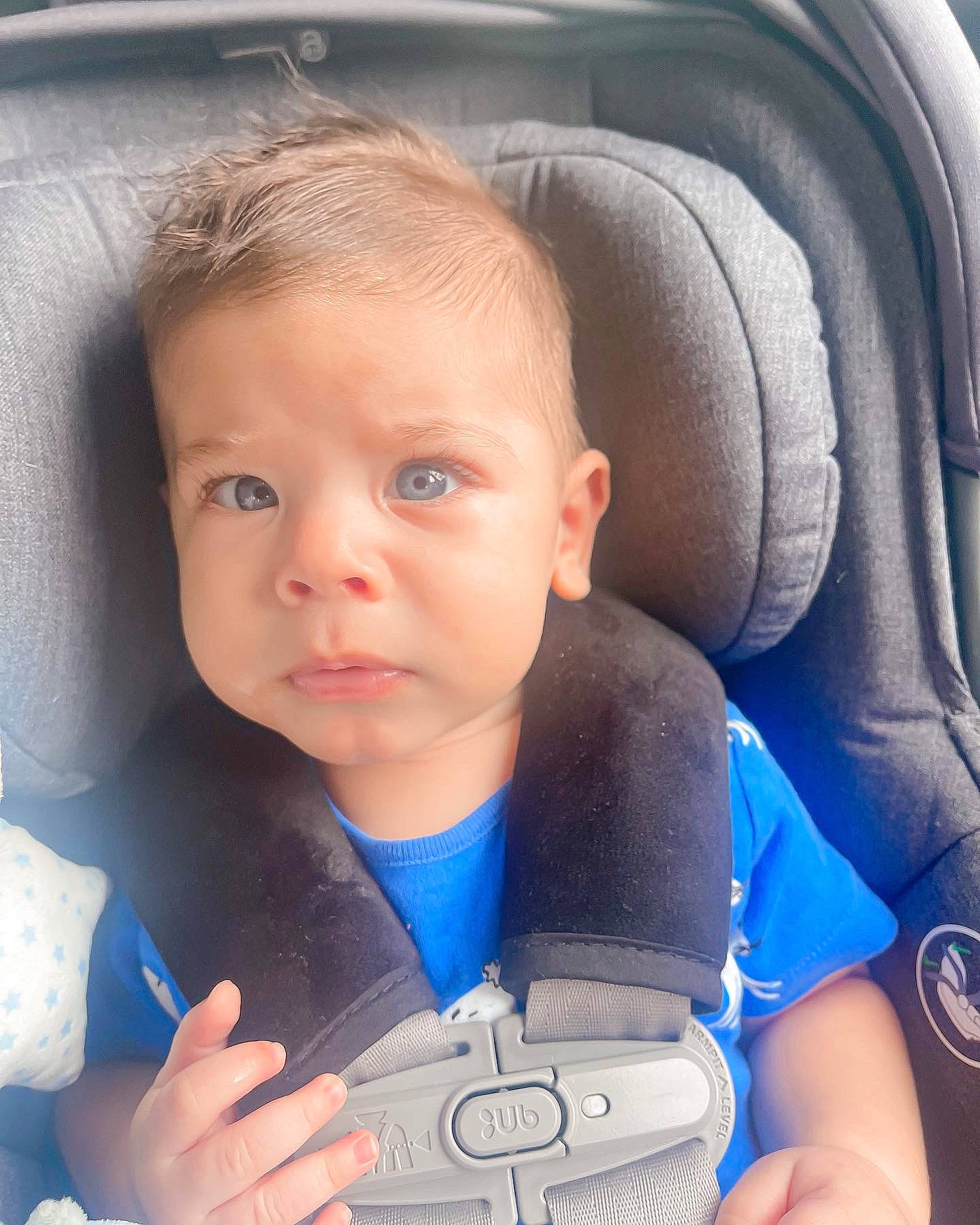 Cameron is registered to the contest to win money with this photo: azure, baby, blue, car_seat, cheek, child, comfort, eye, face, finger, gesture, hand, head, human_body, nose, person, product, skin, thumb, toddler