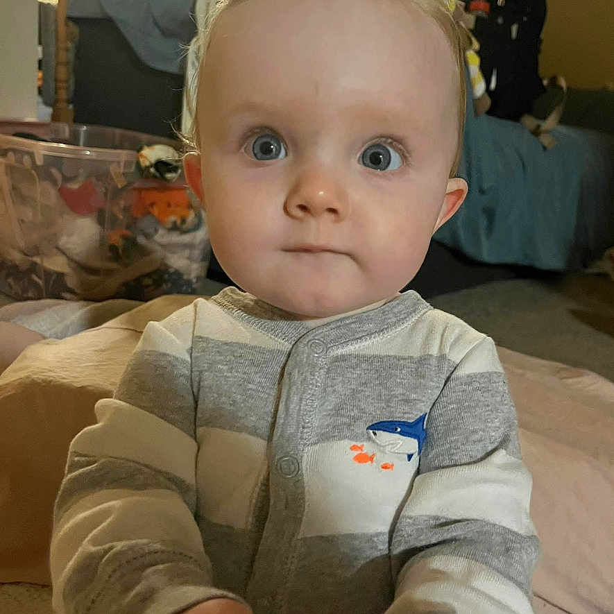 Kasper Nyhart joined the competition — help win amazing prizes! baby, child, indoor, onesie, toy, blue_eyes, curious, person, face, hands, striped_clothing, infant, home, carpet, furniture, soft_lighting, portrait, young_child, cute, expression