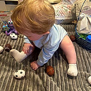 Kasper Nyhart joined the competition — help win amazing prizes! baby, blue_onesie, plush_toy, purple_octopus, toy_balls, gray_blanket, nursing_pillow, basket, stuffed_animal, floor, infant, child, playtime, indoors, soft_texture, cute, crawling, sock, hair, curious