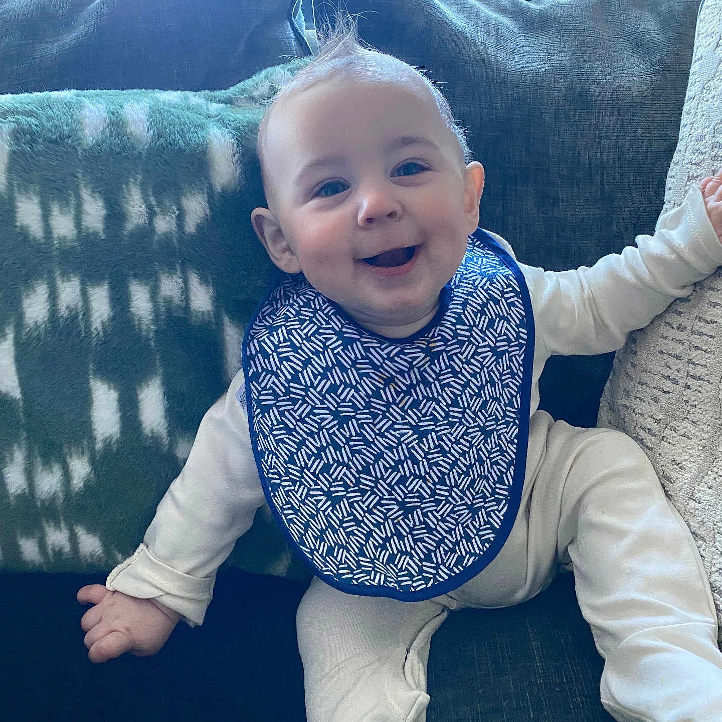 Renn joined the competition — help win amazing prizes! baby, bib, blanket, child, clothing, couch, cozy, face, hair, happy, head, home, indoors, infant, pattern, person, pillow, sitting, smile, young