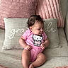 Elianys joined the competition — help win amazing prizes! baby, infant, pink_onesie, hello_kitty, couch, pillows, soft_texture, curly_hair, earrings, beige, pink, child, indoor, seated, cute, portrait, plush, comfort, relaxed, looking_away