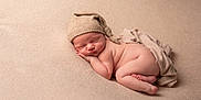 Lévy a rejoint le concours — aidez-le/la à gagner de superbes lots ! newborn, baby, sleeping, hat, knitted_hat, blanket, soft_texture, skin, infant, peaceful, cute, portrait, closeup, cozy, resting, child, naked, warm_colors, gentle_lighting, toddler