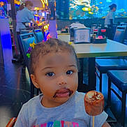 Symiah F is registered to the contest to win money with this photo: aquarium, chair, child, chocolate, clothing, colorful, cute, face, fish, food, hair_clips, indoor, mouth, people, restaurant, seated, smudge, stick_food, table, toddler