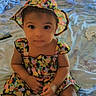 toddler, child, baby, hat, dress, bed, pillow, window, blinds, bottle, indoor, cute, sitting, colorful, pattern, person, young_child, portrait, clothing, furniture