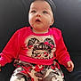 Ivy joined the competition — help win amazing prizes! baby, child, infant, red_clothing, headband, black_headband, bow, camo_pants, sitting, curious, indoor, portrait, cute, wide_eyes, looking_up, hands, face, young_child, casual_wear, colorful